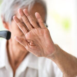Asian senior woman making stop gesture with palm,against domesti